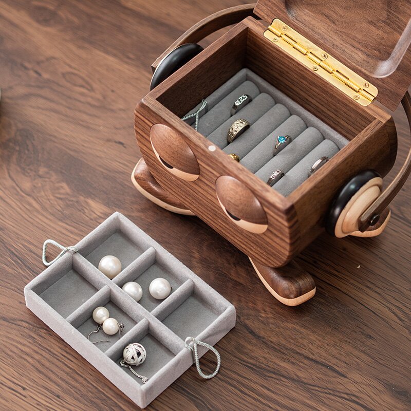 Open wooden octopus jewelry box with soft gray velvet interior, used for storing rings and earrings